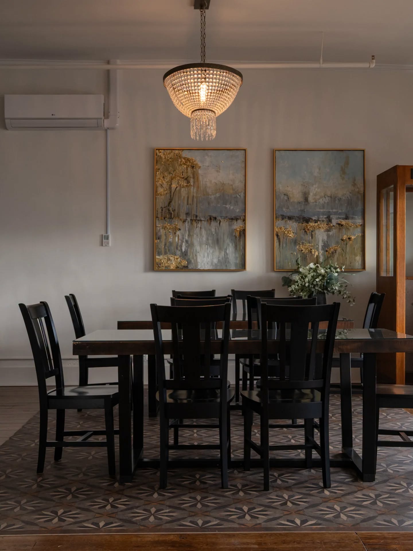 Historic Hattie House communal dining room beneath a crystal chandelier